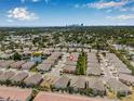 An aerial view showcases the neighborhood with water feature and manicured lawns with the city skyline in the background at 5176 6Th N St, St Petersburg, FL 33703