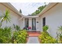 Home entrance featuring a cozy seating area with chairs and lush landscaping at 5219 4Th S St, St Petersburg, FL 33705