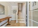 Bright entryway with tiled floors, staircase, wooden console table, and decorated mirror creating a welcoming space at 6140 Marina Cove S Way, St Petersburg, FL 33712