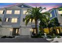 Townhome featuring a mix of blue, grey, and cream colors, complemented by a large palm tree in the front yard at 6140 Marina Cove S Way, St Petersburg, FL 33712