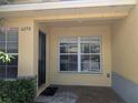 Inviting covered townhome entrance with brick flooring and lush landscaping at 6250 Maisie Rd, Zephyrhills, FL 33542