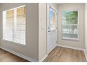 Inviting entryway featuring wood-look flooring and ample natural light through the windows at 6250 Maisie Rd, Zephyrhills, FL 33542