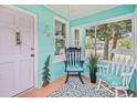 Inviting turquoise front porch featuring rocking chairs and stylish decor at 653 E Spruce St, Tarpon Springs, FL 34689