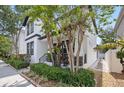 Side view of a well-maintained home with lush greenery, a manicured garden, and a charming walkway at 7307 S Trask St, Tampa, FL 33616