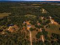 Stunning aerial view of a rural property with a home, surrounded by lush greenery and trees at 8755 Ogleby Creek Rd, Myakka City, FL 34251