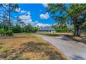 Beautiful one-story home with a spacious wraparound porch and a peaceful, sprawling lawn at 8755 Ogleby Creek Rd, Myakka City, FL 34251