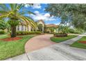 Beautiful Mediterranean-style home featuring lush landscaping, a brick driveway and meticulous lawn at 9818 Tree Tops Lake Rd, Tampa, FL 33626