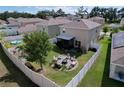 Aerial view of a spacious backyard with a fire pit, seating, manicured landscaping, and a white fence at 11013 Leland Groves Dr, Riverview, FL 33579