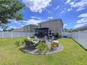 Spacious backyard with a fire pit, seating area, manicured landscaping, and a white fence at 11013 Leland Groves Dr, Riverview, FL 33579