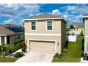 Beige two-story home with two-car garage and well-manicured landscaping in a sunny neighborhood at 11013 Leland Groves Dr, Riverview, FL 33579