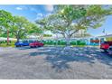 Exterior shot of the condo, featuring mature trees, and a parking area with multiple cars at 11200 102Nd Ave # 75, Seminole, FL 33778