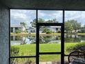Serene view from the screened patio overlooking the lush lawn, tranquil pond and community pool at 11201 122Nd Ave # 129, Largo, FL 33778