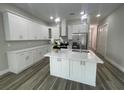 Bright kitchen featuring white cabinets, stainless steel appliances, quartz countertops, and a center island with a sink at 12308 Pittsfield Ave, Tampa, FL 33624