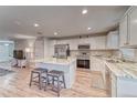 Bright and modern kitchen with stainless steel appliances, an island with seating, and white cabinets at 13822 Harvestwood Ln, Riverview, FL 33569