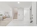 Bright foyer with white tile flooring, stairs, and access to the living area and bathroom at 13934 Clubhouse Cir # 8, Tampa, FL 33618