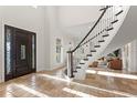 Inviting foyer featuring a curved staircase, stone floors, and elegant wood front door at 17129 Breeders Cup Dr, Odessa, FL 33556
