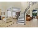 Bright foyer features a curved staircase with iron railings and an adjacent seating area at 18107 Sugar Brooke Dr, Tampa, FL 33647