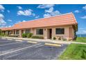 Waterfront condominium features a terracotta tile roof, assigned parking, and mature landscaping at 19029 Us Highway 19 N # 31F, Clearwater, FL 33764