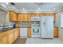 Classic kitchen design features wood cabinetry, granite countertops, and white appliances at 19029 Us Highway 19 N # 31F, Clearwater, FL 33764