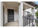 A private entrance featuring a screened door, overhead lighting, and textured stucco walls at 2597 Countryside Blvd # 206, Clearwater, FL 33761