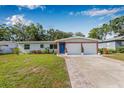 Charming single-story home featuring brick accents, a blue front door, and a well-maintained lawn at 308 Jeanal Pl, Tampa, FL 33612