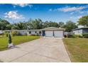 Picture of the exterior showcasing a single-story home with a manicured lawn and a spacious two-car garage at 308 Jeanal Pl, Tampa, FL 33612
