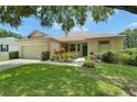 Inviting single-story home featuring a green front door, attached garage, and lush green lawn at 3333 Michener Pl, Plant City, FL 33566