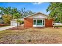Charming single-story brick home with a bay window, landscaped yard, and palm tree at 3417 1St W Ave, Bradenton, FL 34205