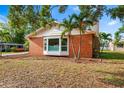 Charming brick home featuring a bay window, chimney, and lush landscaping with palm trees at 3417 1St W Ave, Bradenton, FL 34205