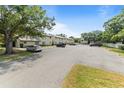 Exterior shot of a condominium complex with an ample parking lot and mature trees at 4215 East Bay Dr # 1103D, Clearwater, FL 33764