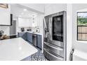 Bright, modern kitchen with stainless steel appliances, quartz counters, and blue and white patterned tile flooring at 4432 W Mccoy St, Tampa, FL 33616