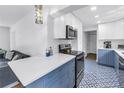 Open kitchen featuring quartz countertops, sleek appliances, stylish tile floors and blue bottom cabinets at 4432 W Mccoy St, Tampa, FL 33616
