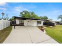 Stylish single-story home featuring a covered parking area and vibrant landscaping around the manicured lawn at 4681 70Th N Ave, Pinellas Park, FL 33781