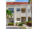 Inviting two-story condo featuring a red tile roof, lush landscaping, and convenient parking at 6171 Bahia Del Mar Blvd # 216, St Petersburg, FL 33715