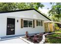 Close up of the renovated single-story home featuring black trim, black door, and manicured yard at 8277 82Nd N Ave, Largo, FL 33777