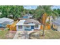 Aerial view of a cozy single-story home featuring a fenced yard, driveway, and tidy landscaping at 4210 E Grove St, Tampa, FL 33610