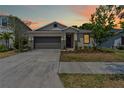Charming single-story home featuring a well-manicured lawn and stone veneer accents at 10563 Laguna Plains Dr, Riverview, FL 33578