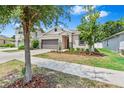 Charming single-story home featuring a well-manicured lawn and stone veneer accents at 10563 Laguna Plains Dr, Riverview, FL 33578