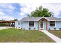 Light blue home showing off driveway carport and landscaping, creating an inviting curb appeal at 1114 Michigan N Dr, Dunedin, FL 34698