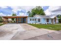 View of the exterior of a charming home highlighting the carport and inviting front lawn at 1114 Michigan N Dr, Dunedin, FL 34698