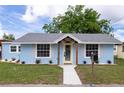 Front exterior view of a light blue home showcasing fresh landscaping, newer roof and charming curb appeal at 1114 Michigan N Dr, Dunedin, FL 34698