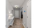 Bright hallway with tile flooring, featuring a stylish console table and decor at 12607 Flatwood Creek Dr, Riverview, FL 33578