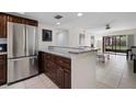 Open kitchen view with granite countertops, stainless appliances, tile floors, and seamless access to the living area at 12900 Vonn Rd # F101, Largo, FL 33774