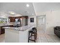 Bright kitchen boasting granite countertops, stainless steel appliances, tile floors, and a breakfast bar at 12900 Vonn Rd # F101, Largo, FL 33774