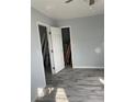 Bedroom showing updated gray flooring and fresh paint with doors to closet and bathroom at 14067 Marguerite Dr, Madeira Beach, FL 33708