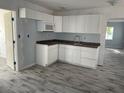 Updated kitchen featuring white cabinets, gray countertops, and new appliances at 14067 Marguerite Dr, Madeira Beach, FL 33708