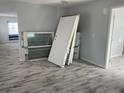 Open living room showcasing new gray flooring, fresh paint, and natural light from new windows at 14067 Marguerite Dr, Madeira Beach, FL 33708