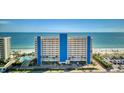 Exterior view of a beachfront condo building with a pool, palm trees, and ocean view at 15000 Gulf Blvd # 602, Madeira Beach, FL 33708