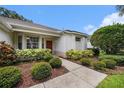 Inviting front entrance with manicured shrubs and mulch, leading to a warm-toned front door at 1744 Brookstone Way, Plant City, FL 33566