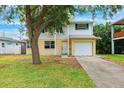 Charming two-story home featuring white and yellow siding, a well-maintained lawn, and an attached single-car garage at 1810 Maryland Ne Ave, St Petersburg, FL 33703